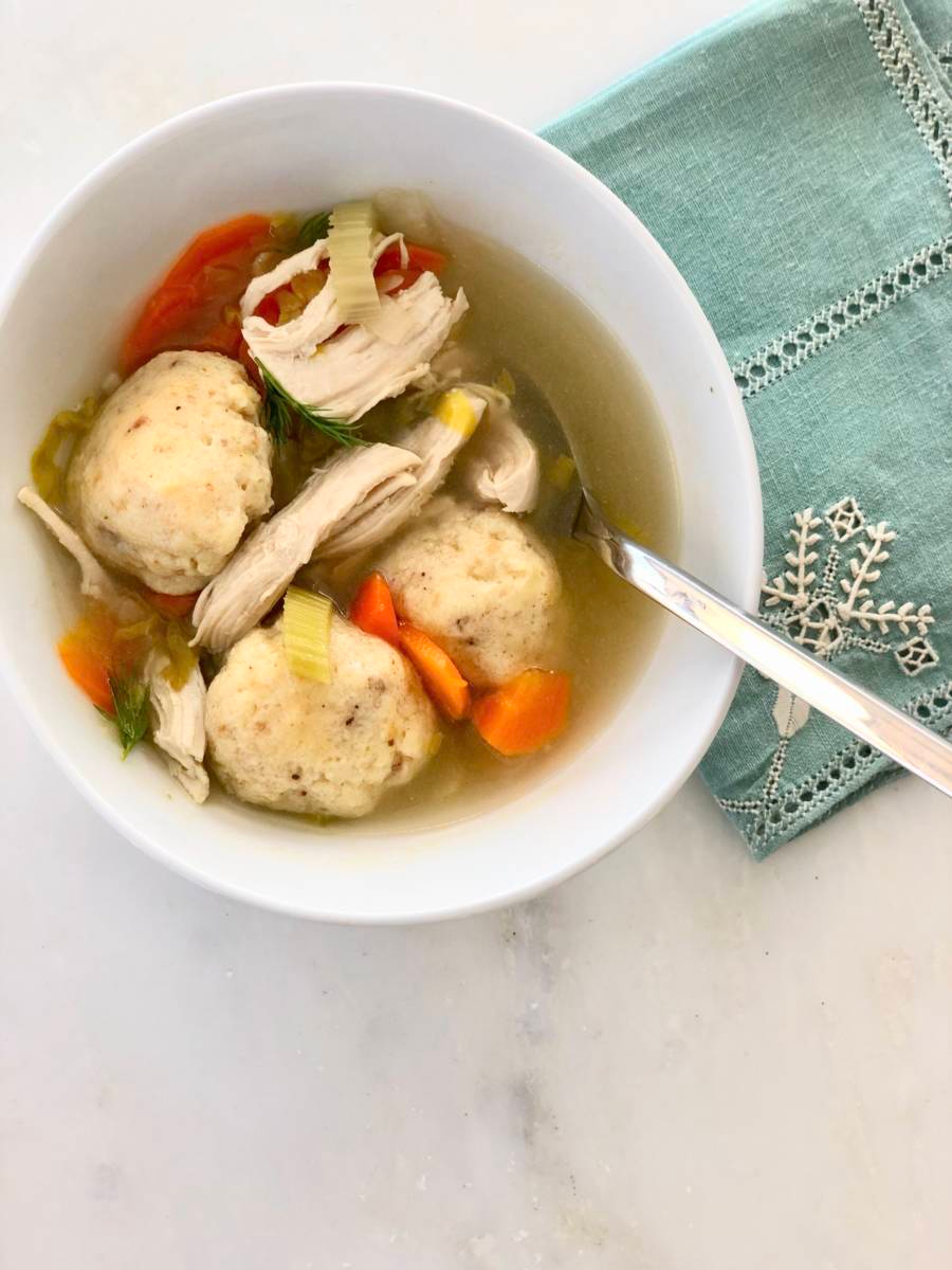 Closeup of matzo ball soup on a bowl.